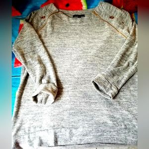 Gray lightweight sweater with gold keyholes and gold zippers angled at shoulders